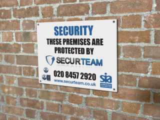 custom printed security board displayed on brick